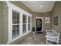 Cozy front porch features a bench and windows with white trim and a storm door at 2018 Links View Dr, Fort Mill, SC 29707