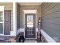 Close-up of the inviting front door with decorative welcome sign and stylish accents at 250 Kerri Dawn Ln, Locust, NC 28097