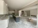Spacious interior showcasing a gray island, white cabinets, fireplace and staircase under construction at 2720 Old Course Rd, Monroe, NC 28112