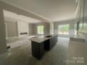 Bright living area with a modern gray island, beautiful countertops, and a decorative fireplace at 2720 Old Course Rd, Monroe, NC 28112