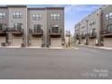 Row of modern townhomes featuring attached garages and small balconies, set along a paved street at 3750 Ellington St, Charlotte, NC 28211