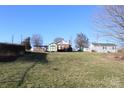 Expansive backyard showcasing a shed and neighboring homes, all under a bright blue sky at 410 Cole Campbell Rd, Taylorsville, NC 28681