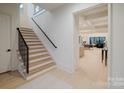 Bright entryway featuring a staircase with black railing, with an open view into the kitchen and living areas at 412 Bertonley Ave, Charlotte, NC 28211