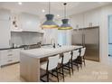 Stylish kitchen island with white marble countertop, stainless steel refrigerator, and seating for four at 412 Bertonley Ave, Charlotte, NC 28211