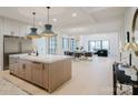 Spacious kitchen and open-concept with island, stainless steel appliances, and bright lighting adjacent to the living room at 412 Bertonley Ave, Charlotte, NC 28211