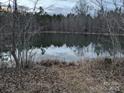 Beautiful still pond surrounded by trees, reflecting the sky, at the edge of this expansive property at 4926 Stack Rd, Monroe, NC 28112