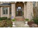 Elegant brick home entrance with decorative floral wreath, covered portico, and manicured flowerbeds at 507 Saint Johns Dr, Salisbury, NC 28144