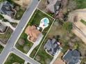 Aerial view of property showcasing its layout, pool area, landscaping, and surrounding neighborhood at 5501 Two Iron Dr, Matthews, NC 28104