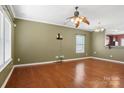 Spacious living room featuring gleaming hardwood floors, natural light, and a ceiling fan for comfortable living at 616 Smokehouse Ln, Albemarle, NC 28001