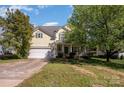 Two-story home with attached garage, covered front porch, and tidy front lawn at 6720 Neuhoff Ln, Charlotte, NC 28269