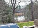 Picturesque lake view from the backyard with a glimpse of the house, set amidst a serene wooded landscape at 810 Wynnshire Dr # D, Hickory, NC 28601