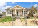 Charming home featuring a covered front porch with columns and a fenced yard under a sunny sky at 1111 W 4Th Ave, Gastonia, NC 28052