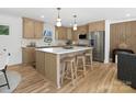 This modern kitchen features an island with seating, stainless steel appliances and hardwood floors at 1200 Carey Ct, Charlotte, NC 28210