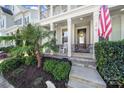 Inviting front porch showcasing rocking chairs, manicured landscaping, and an American flag at 124 Helton Ln, Fort Mill, SC 29708