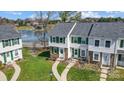 An aerial view shows the townhomes near a lake, with walkways, parking, and landscaping at 130 Water Oak Dr, Pineville, NC 28134