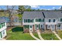 An elevated view of the townhome shows the green shutters, landscaping, and proximity to the lake at 130 Water Oak Dr, Pineville, NC 28134