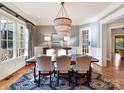 Elegant dining room features a modern chandelier, hardwood floors and large windows at 1355 Wyndmere Hills Ln, Matthews, NC 28105