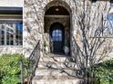 Elegant stone archway frames the front door, creating a grand entrance with detailed stonework and iron railings at 1355 Wyndmere Hills Ln, Matthews, NC 28105