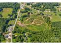 This aerial view showcases a spacious lot, bounded by vibrant trees and adjoining a quiet road at 1414 S Post Rd, Shelby, NC 28152