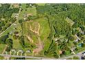 This aerial view showcases a verdant lot, surrounded by lush trees and bordering a peaceful road at 1414 S Post Rd, Shelby, NC 28152