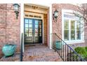 Close up of the front door with brick stairs, iron railings, and detailed lighting fixtures at 17201 Royal Court Dr, Davidson, NC 28036