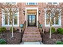 Inviting entryway with brick steps, black iron railings, and stylish outdoor lighting at 17201 Royal Court Dr, Davidson, NC 28036