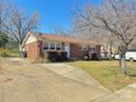 View of the home with a paved driveway, manicured bushes and classic brick facade at 2210 Milton Rd, Charlotte, NC 28215