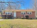 Classic brick home featuring manicured shrubs, a well-kept lawn, and a welcoming facade at 2210 Milton Rd, Charlotte, NC 28215