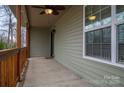 Spacious covered porch with wood railing, exterior ceiling fan and ample room for outdoor seating and entertainment at 3155 Ramseur St, Lincolnton, NC 28092