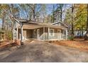 View of the front exterior of the house and the front yard with a long driveway and a covered carport at 325 Spring Oak Dr, Salisbury, NC 28147