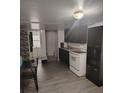 The eat-in kitchen provides black cabinets, white appliances and wood look floors at 348 Grice St, Shelby, NC 28150