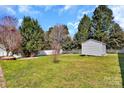 Lush green backyard featuring a storage shed and a pristine white fence at 4007 Hermes Ln, Waxhaw, NC 28173