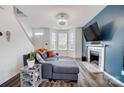 Bright living room with a plush sectional sofa, fireplace, and bright natural light streaming through the windows at 405 Goldstaff Ln, Charlotte, NC 28273