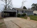 View of home and car port showing the brick exterior, concrete driveway, and convenient parking at 4408 Pebblebrook Dr, Charlotte, NC 28208