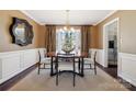 Elegant dining room with hardwood floors, modern chandelier, and large window with backyard view at 4811 Dawnridge Dr, Charlotte, NC 28226