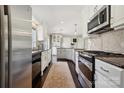 Modern kitchen features stainless steel appliances, granite countertops, white cabinets, and hardwood floors at 4811 Dawnridge Dr, Charlotte, NC 28226