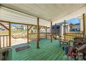 Inviting back porch with green flooring offers an outdoor space with railing and furniture at 60 Central Ave, Gastonia, NC 28054