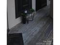 Cozy wooden floor balcony features a welcome mat and potted plants at 8149 Cedar Glen Dr # 8149, Charlotte, NC 28212