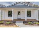 Inviting front entrance with a covered porch, white columns, and a well-manicured lawn at 818 E Charles St, Matthews, NC 28105