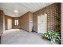 Spacious hallway with tiled floors, brick walls, and a view of unit's entrance with a green plant at 84 Lake Concord Ne Rd # S, Concord, NC 28025