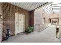 Well-lit hallway with brick walls, carpet flooring, and a skylight, leading to the unit's entrance at 84 Lake Concord Ne Rd # S, Concord, NC 28025