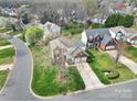 Aerial view of a neighborhood featuring well-manicured lawns and a two-story house with a two car garage at 8620 Grey Squirrel Ct, Charlotte, NC 28277