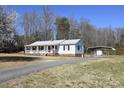 View of the house with carport, and long driveway leading to the street, surrounded by trees at 1020 Saint Paul Church Rd, Clover, SC 29710