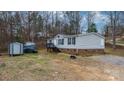Inviting home with vinyl siding, a sturdy brick foundation, front stairs, and a detached storage shed at 109 Dogwood Dr, Hickory, NC 28601