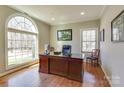 Bright office space with a large arched window, hardwood floors, and a spacious desk at 11243 Home Place Ln, Mint Hill, NC 28227