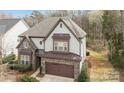 Exterior elevation of two-story home features manicured lawn and an attached two-car garage at 13725 Laughing Gull Dr, Charlotte, NC 28278