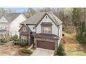 Aerial view of a stately home with stone and shake siding, a large roof, and a well-kept yard at 13725 Laughing Gull Dr, Charlotte, NC 28278