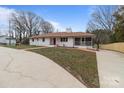 Lovely single-story home with a charming red door, a brick walkway and large shade trees at 1601 Mooresville Rd, Salisbury, NC 28147