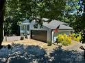 Exterior view of home with large garage, American flag, and manicured landscaping on a sunny day at 18 Pickett Ave, Spencer, NC 28159