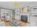Cozy living room with a fireplace, built-in shelving, modern chandelier, and hardwood floors for a warm atmosphere at 2913 Archdale Dr, Charlotte, NC 28210
